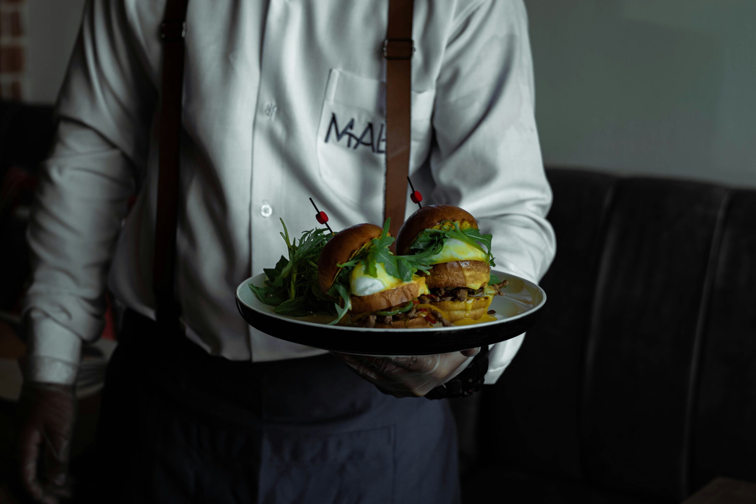 Secret Supper Clubs : A chef plating elegant dishes in a hidden dining space surrounded by a small group of guests.