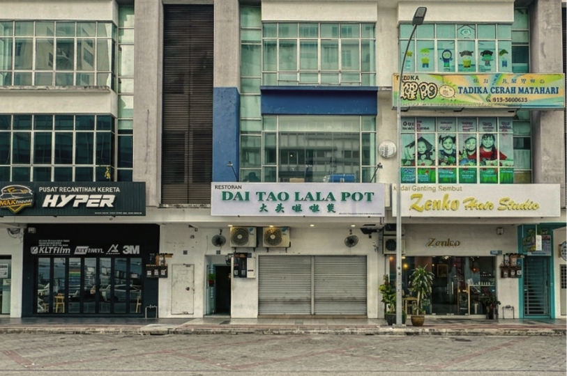 A street-level view of a commercial building storefront featuring a restaurant named "Dai Tao Lala Pot" flanked by a car workshop and a hair studio.