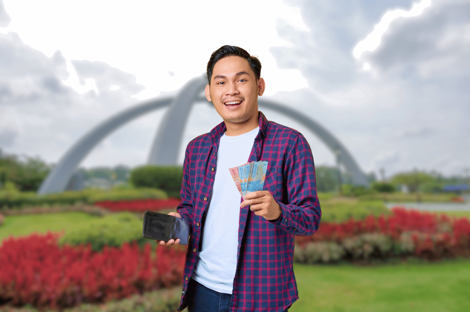 Smiling traveler holding colorful banknotes and a smartphone, standing in front of a modern arch-like structure surrounded by lush gardens. The cloudy sky and architectural backdrop evoke a sense of adventure and discovery—capturing the joy of exploring Johor Bahru’s culinary scene with cash in hand and mobile maps ready.