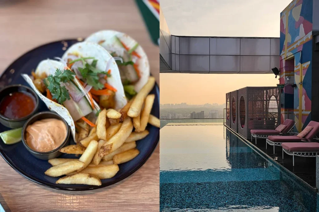 This split-screen image transitions from a close-up meal to a serene poolside view. The left side displays a plate of three soft tacos stuffed with pork belly, pickled vegetables, and fresh cilantro, served alongside a generous portion of thick-cut french fries and two creamy dipping sauces. The right side features a stunning rooftop infinity pool that reflects the soft orange and pink hues of a sunset. Pink lounge chairs sit on the deck next to ornate, dark-screened cabanas, while the hazy silhouette of a city stretches across the horizon in the background.