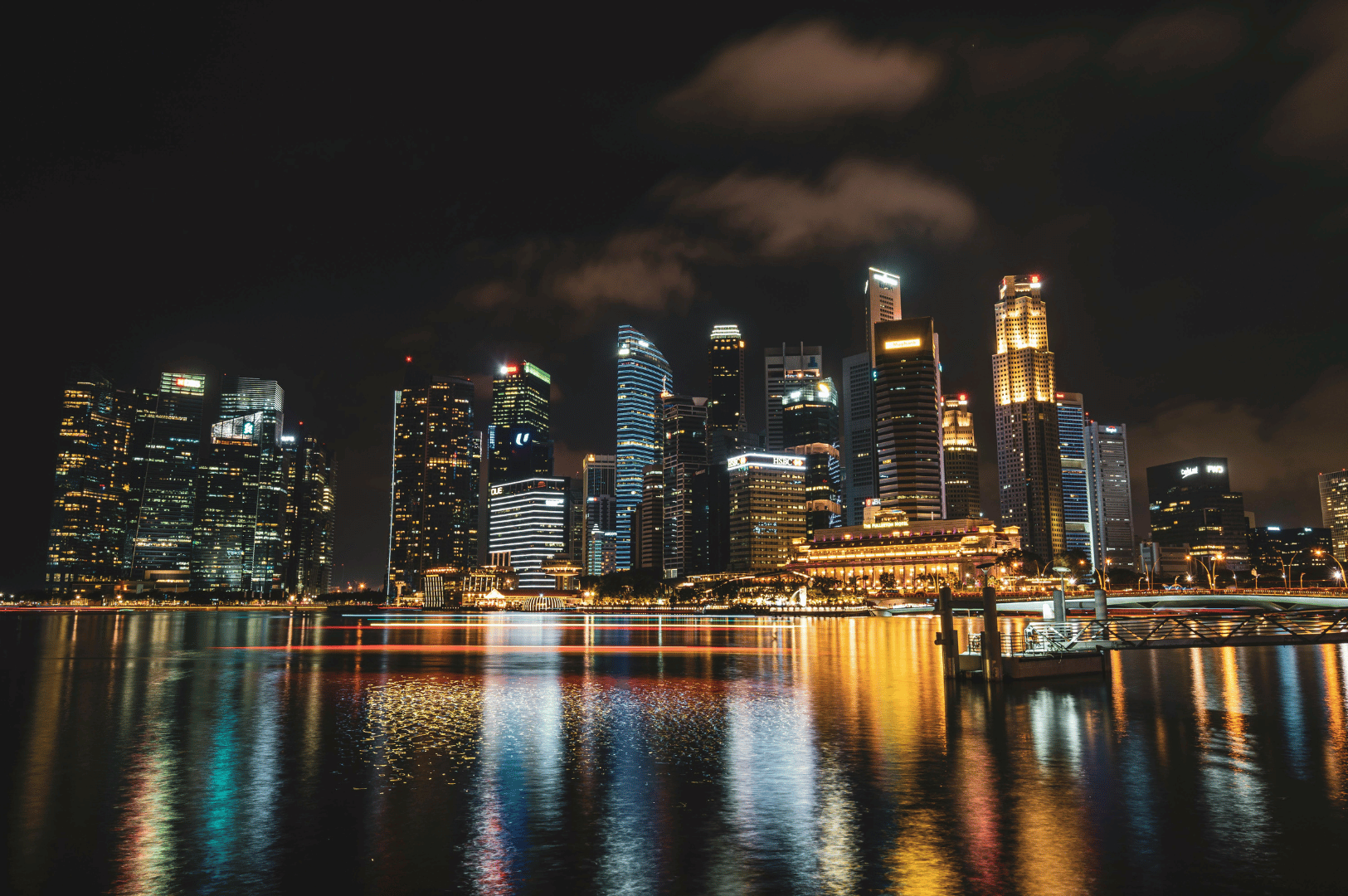 Nighttime skyline of Singapore with illuminated skyscrapers and Marina Bay reflections—ideal backdrop for a guide to the city’s rooftop bars and elevated views.