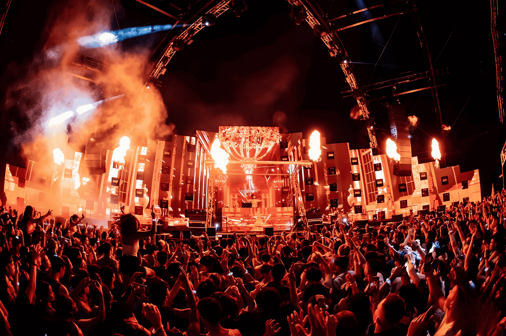 Massive crowd at a Singapore music festival cheering before a grand stage lit with fiery red and orange lights, pyrotechnics, and LED visuals, capturing the scale and intensity of the city’s biggest live music events.
