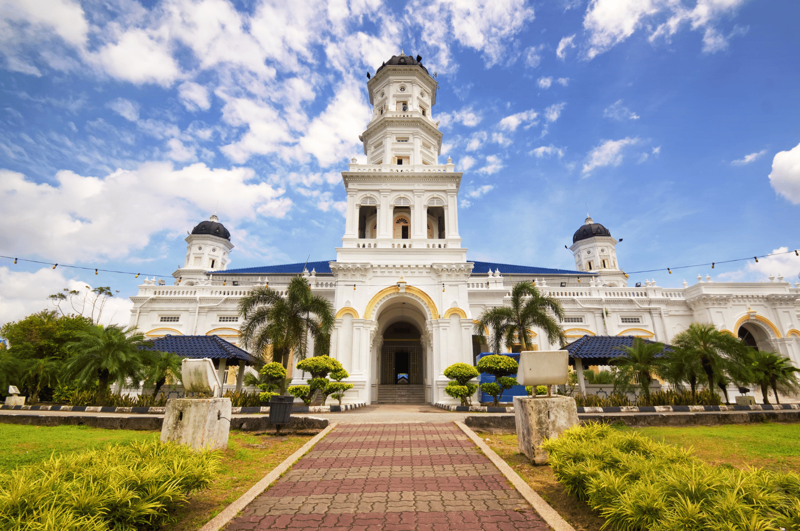 Sultan Abu Bakar State Mosque in Johor Bahru framed by palm-lined gardens and a symmetrical walkway—showcasing the city’s architectural heritage and cultural depth beyond its shopping reputation.