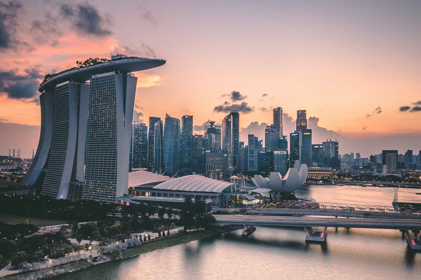 Sunset over Singapore skyline, showcasing Marina Bay Sands, emphasizing exceptional service quality and guest experience.