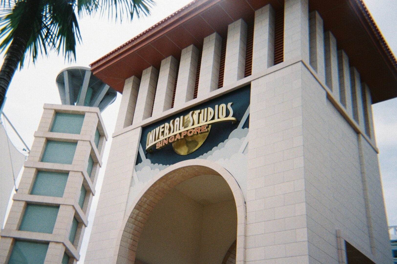 The entrance of Universal Studios Singapore, showcasing a large white building with a distinctive architectural style.