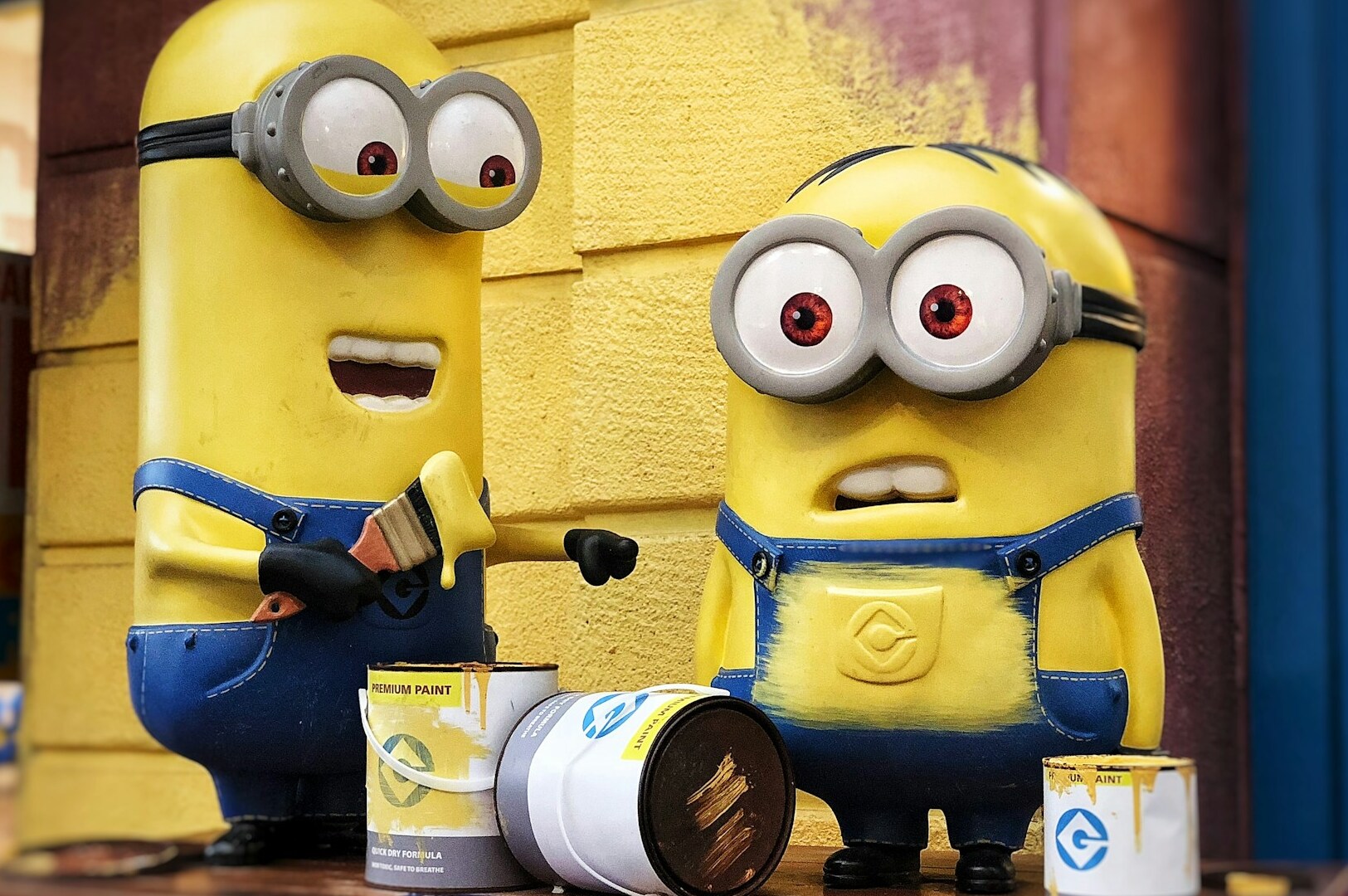Two cheerful minions pose together in Universal Studios Singapore's Minion Land, showcasing their playful personalities.