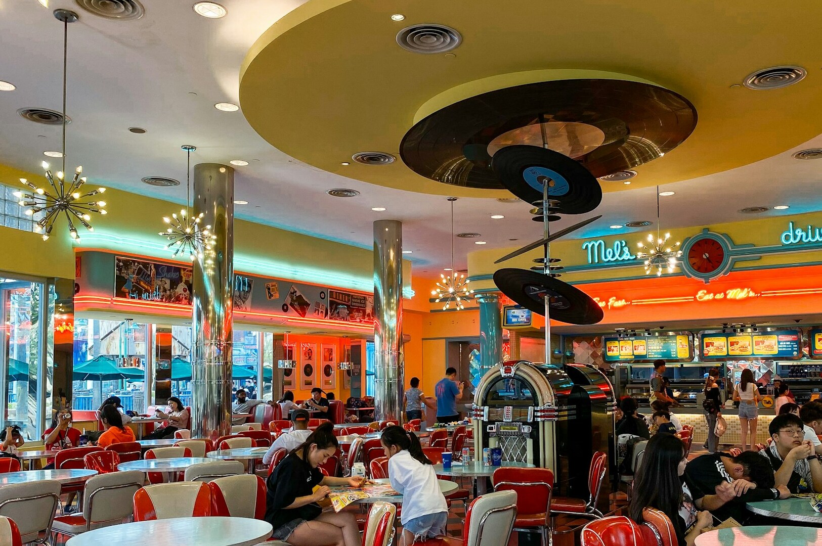 Inside the Universal Studios Singapore Diner, patrons are seated and eating at various tables.