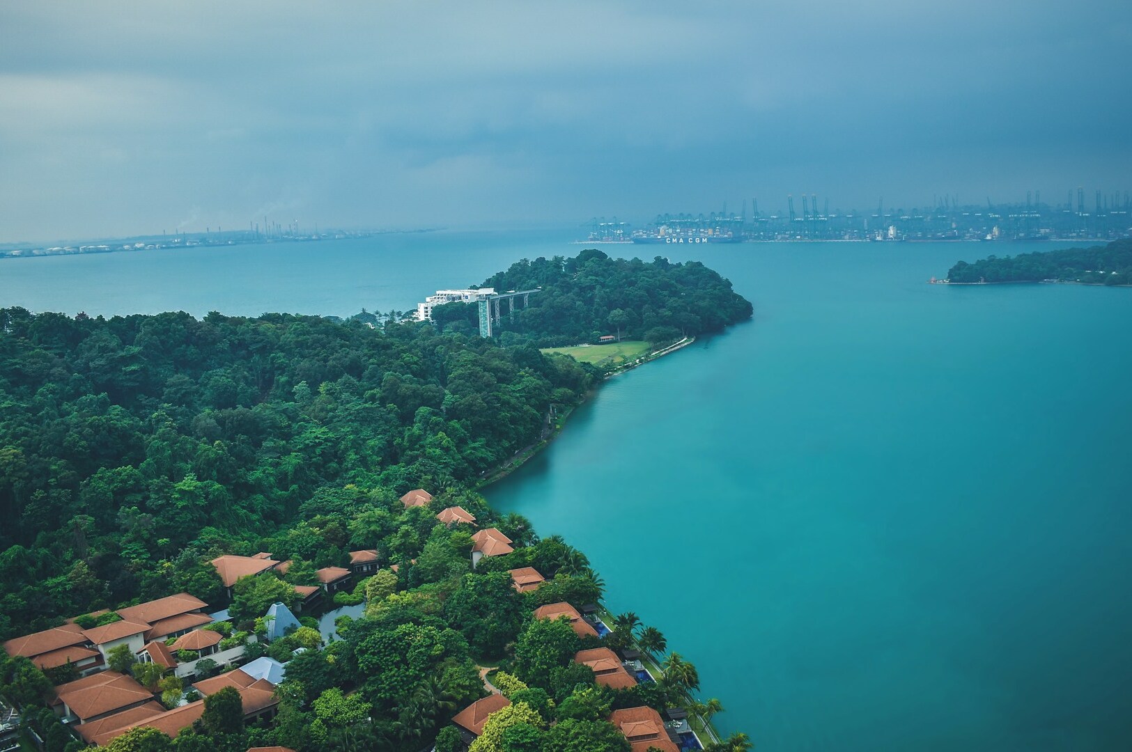 Overhead perspective of Singapore, highlighting the vibrant cityscape and the lush Sentosa Islands.