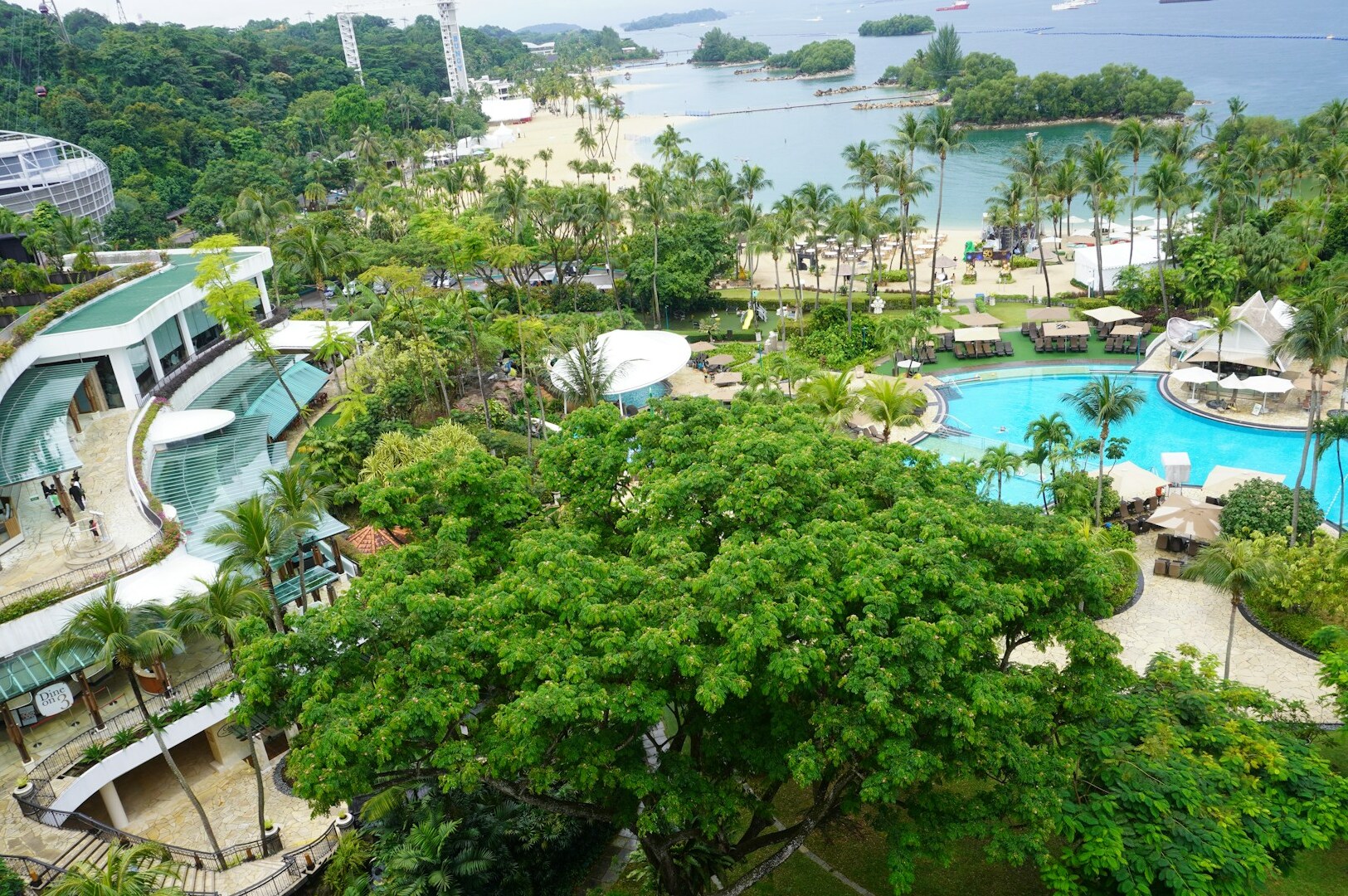 Aerial perspective from Village Hotel Sentosa, featuring the vibrant resort grounds and natural surroundings.