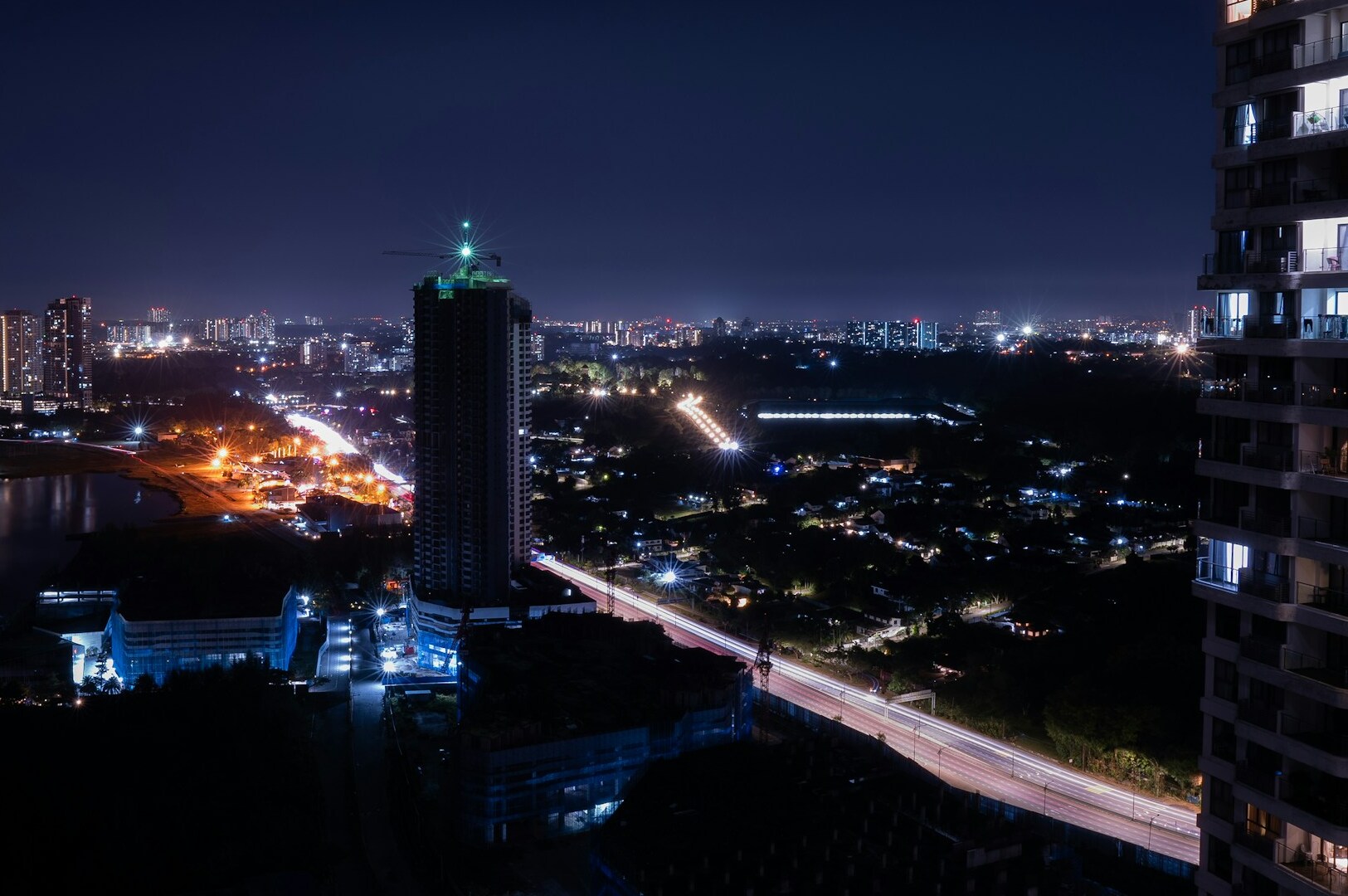 Night view of hotels in Johor Bahru city with long exposure capturing vibrant traffic lights and cityscape.