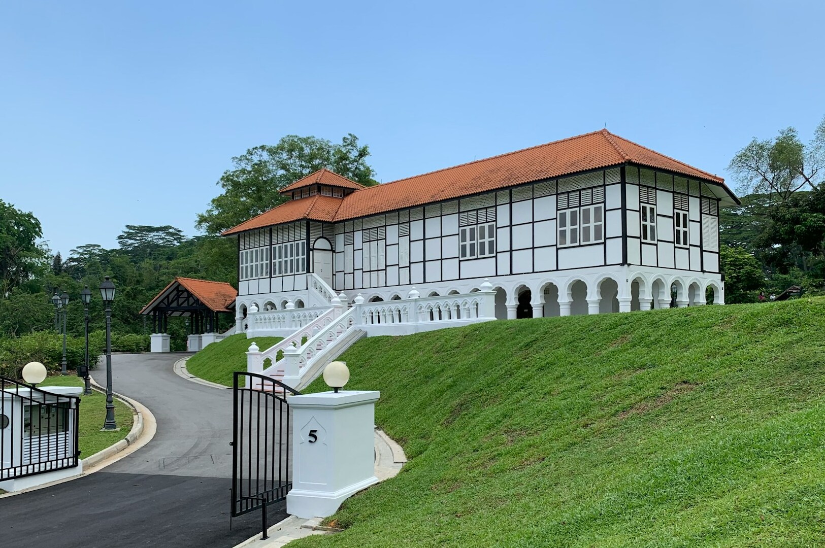 A prominent white house with a red roof atop a hill, located in Holland Village, Singapore.