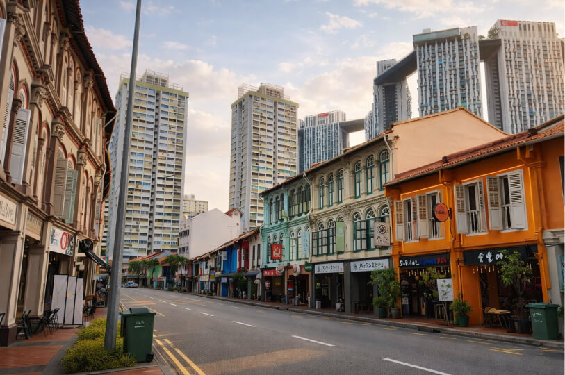 Gemini said A vibrant street view showcasing colorful historic shophouses in the foreground and modern skyscrapers rising in the background.