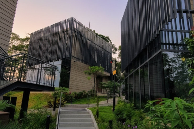 Exterior view of modern villa buildings featuring tan horizontal siding and decorative black vertical slat facades at dusk.