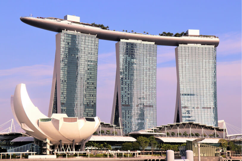 The Marina Bay Sands hotel in Singapore, featuring three glass skyscrapers connected at the top by a large, boat-shaped skypark.