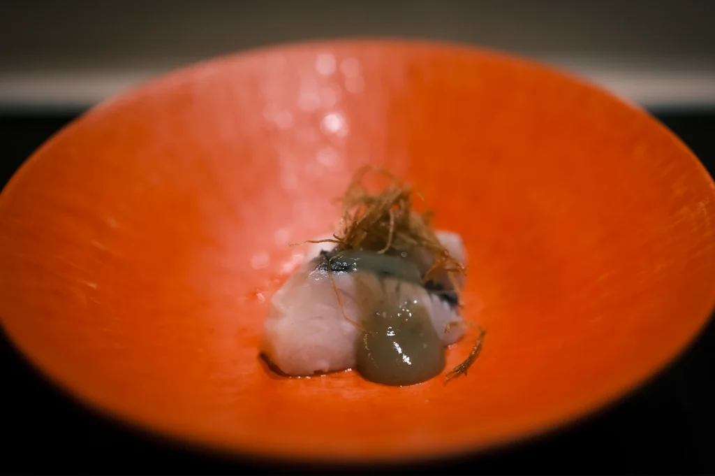 Elegant omakase seafood dish served at Sushi Masa by Ki-setsu in Singapore, presented on a vibrant red plate with delicate Japanese fine dining plating and shallow depth of field photography