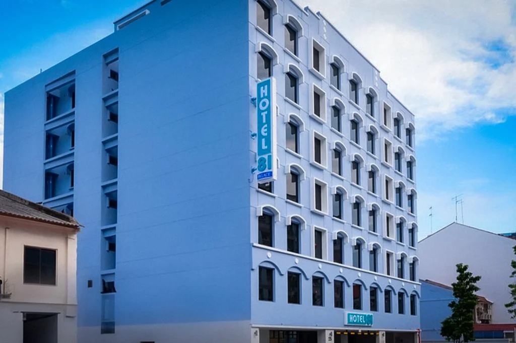 Exterior facade of Hotel 81 Palace in Singapore featuring a modern multi-story blue and white hotel building under a bright daytime sky