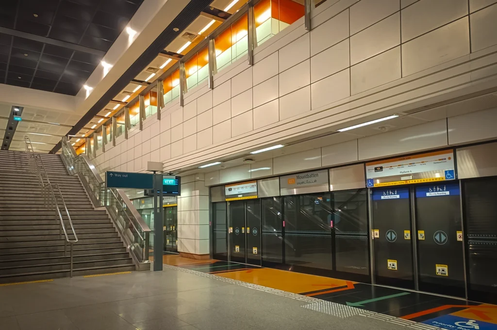 Interior view of Mountbatten MRT Station in Singapore featuring modern platform screen doors escalators staircase access and clean underground station architecture on the Circle Line