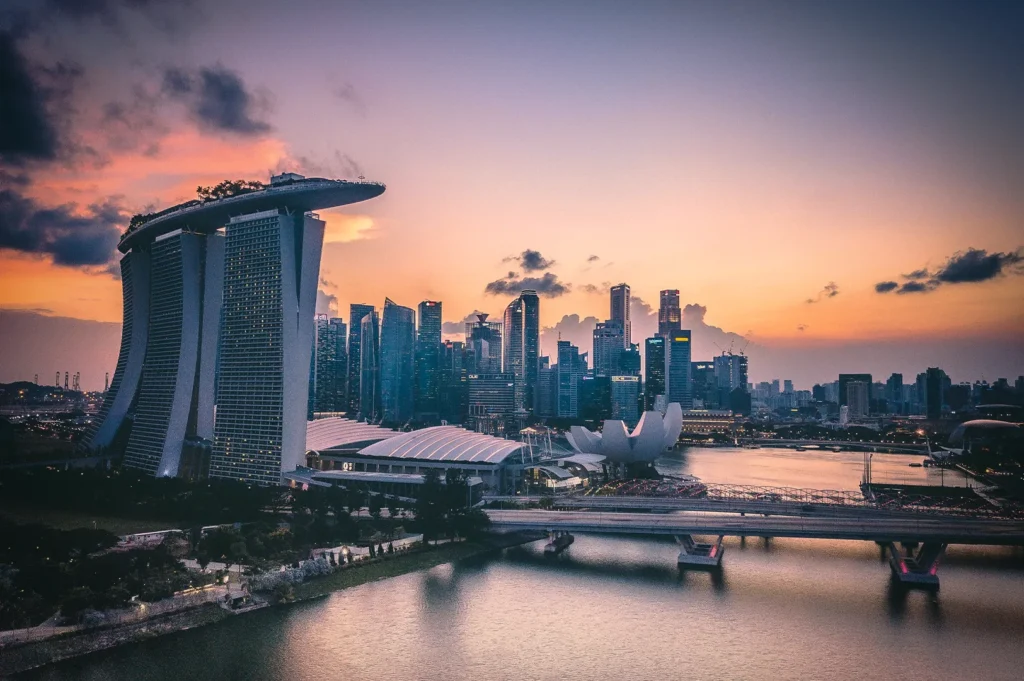 Marina Bay Sands and the Singapore skyline at sunset, featuring iconic waterfront landmarks, modern skyscrapers, and reflections across Marina Bay during golden hour.