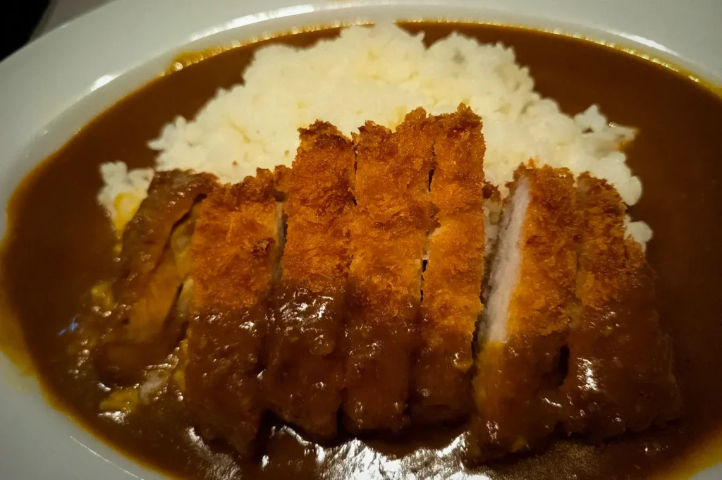 Crispy tonkatsu Japanese curry rice from Maji Curry, featuring breaded pork cutlet slices served over steamed rice with rich savory curry sauce.