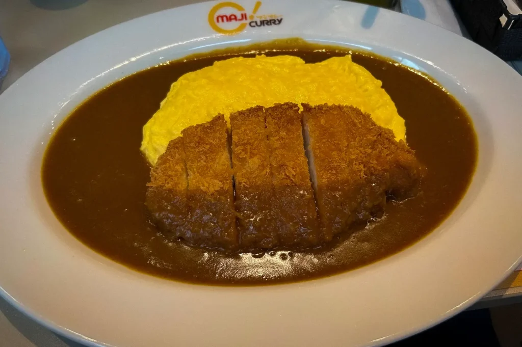 Maji Curry omurice with crispy tonkatsu pork cutlet, fluffy Japanese omelette, and rich curry sauce served on a signature Japanese curry rice platter.