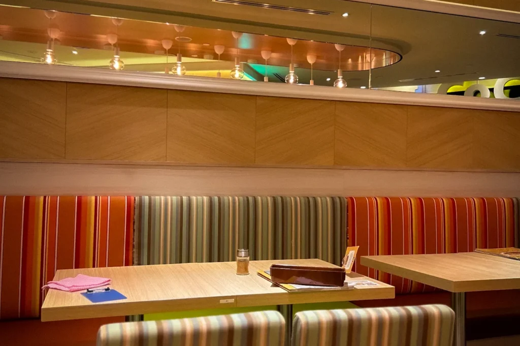 CoCo Ichibanya Singapore restaurant interior featuring striped booth seating, dining tables, warm lighting, and a modern casual dining atmosphere.