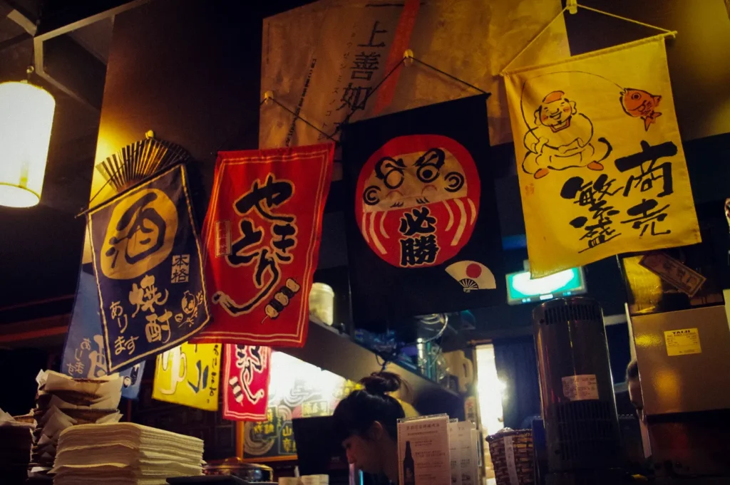 Japanese-style izakaya restaurant in Singapore featuring traditional decorative banners, warm ambient lighting, and an inviting casual dining atmosphere.