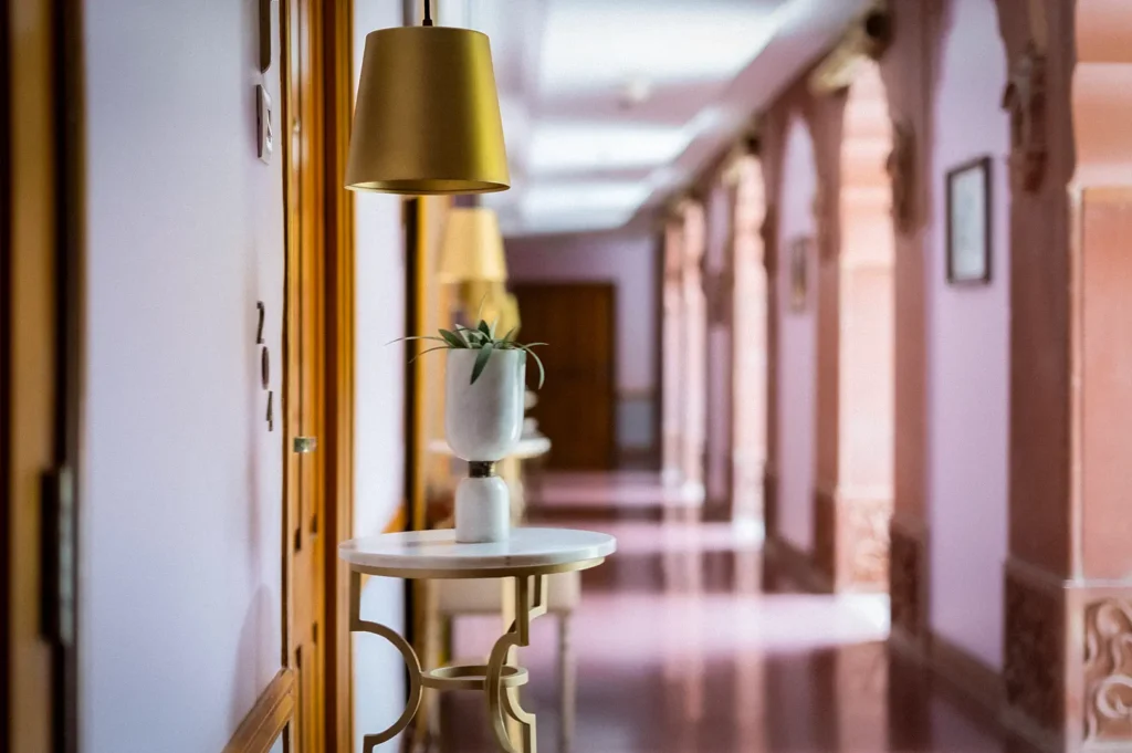 Elegant hotel corridor featuring modern lighting, stylish décor, room entrances, and a minimalist interior with warm ambient lighting and contemporary design.