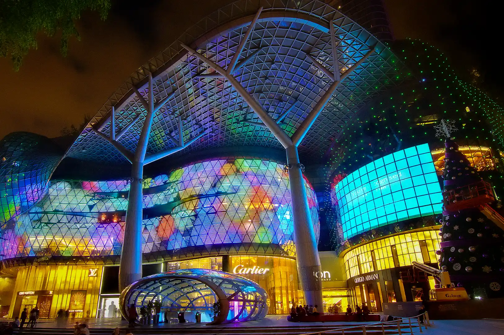 ION Orchard shopping mall illuminated at night on Orchard Road in Singapore, featuring its iconic glass facade, luxury boutiques, and vibrant LED displays.