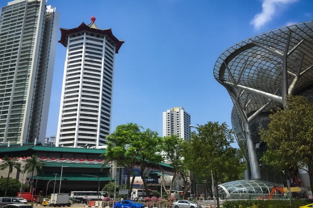 ION Orchard shopping mall and Orchard Road skyline in Singapore featuring modern architecture, busy city streets, and surrounding high-rise buildings on a sunny day.