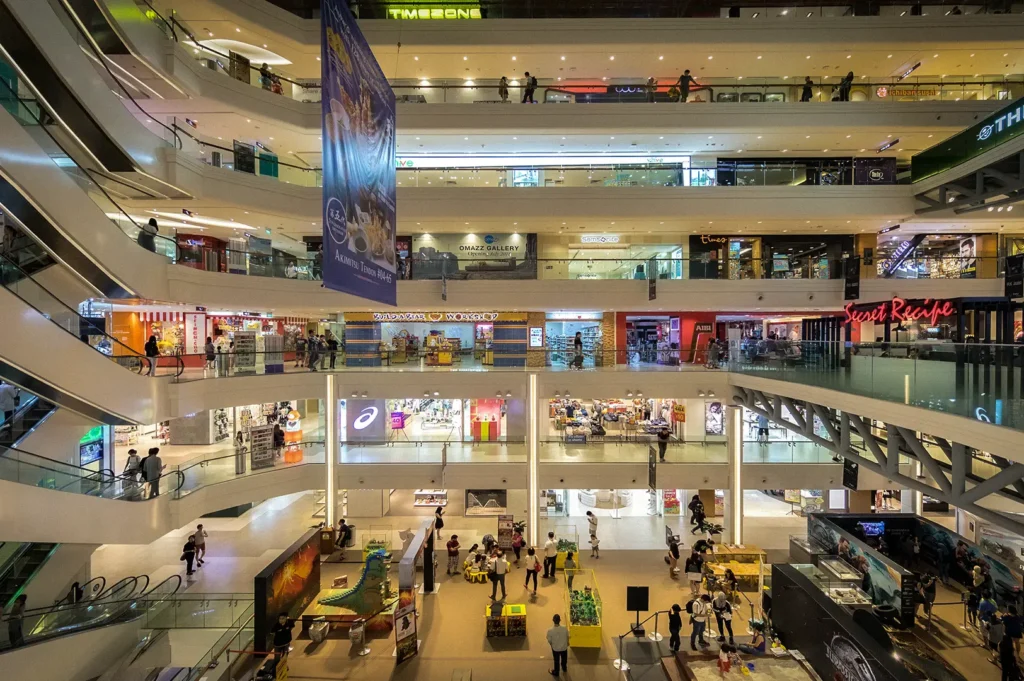 Wide interior view of Plaza Singapura shopping mall on Orchard Road, Singapore, featuring multiple retail levels, escalators, popular stores, dining outlets, and spacious atrium.